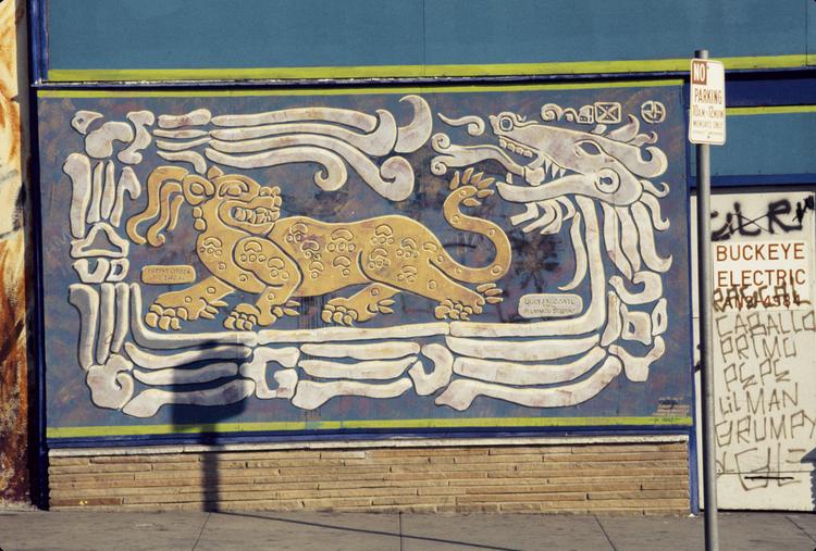 Photo of a blue and gold mural showing a jaguar and serpent surrounded by Indigenous symbols.