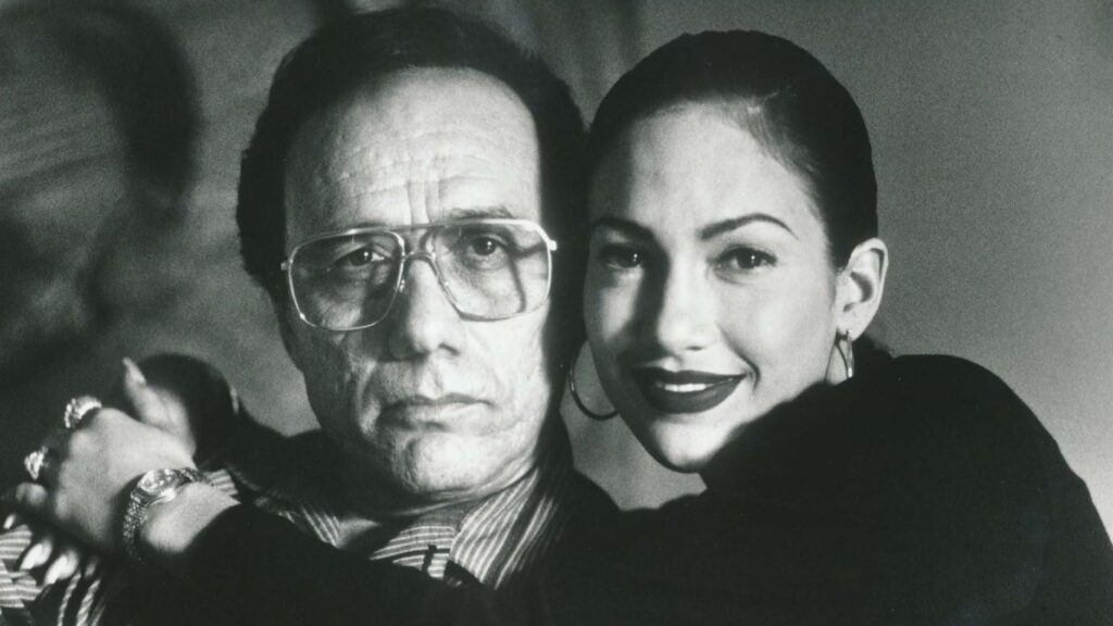 Black and white promotional photo of Edward James Olmos as Abraham Quintanilla Jr and Jennifer Lopez as Selena Quintanilla.