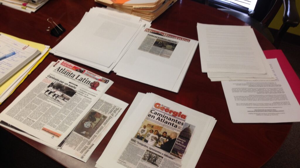 Photos of newspapers and documents spread across a table at the Georgia Latino Alliance for Human RIghts.