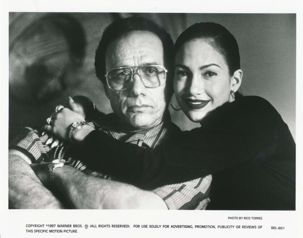 Black and white promotional photo of Edward James Olmos as Abraham Quintanilla Jr and Jennifer Lopez as Selena Quintanilla.