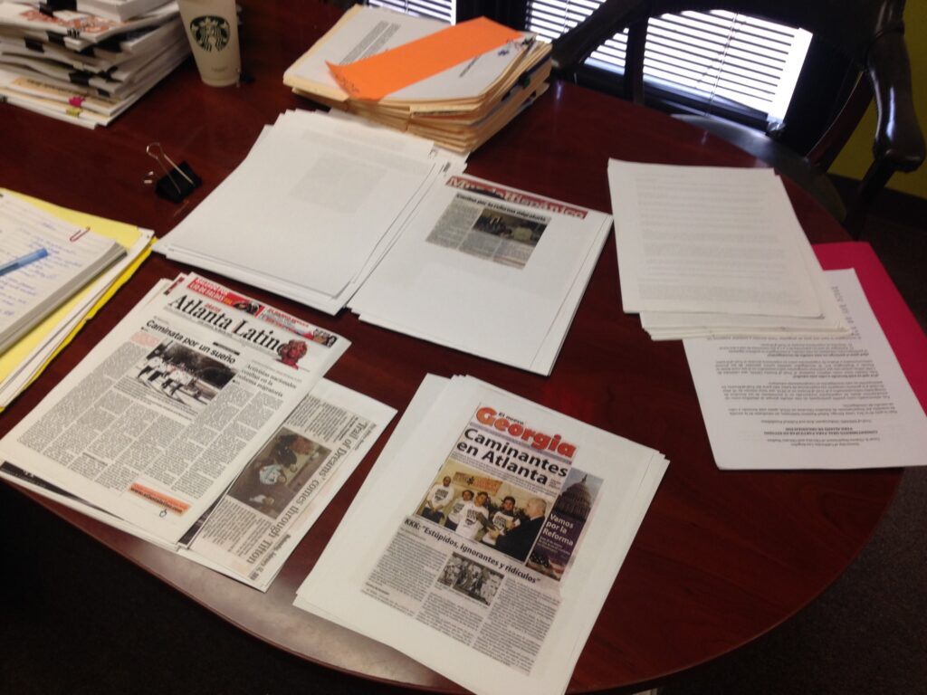 Photos of newspapers and documents spread across a table at the Georgia Latino Alliance for Human RIghts.